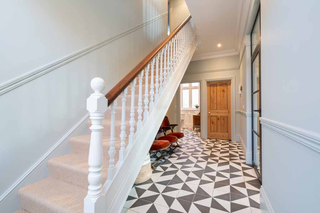 Home office with a desk, chair, and shelving, set against a window overlooking the garden. The workspace is organized and filled with natural light, providing a productive and comfortable environment.